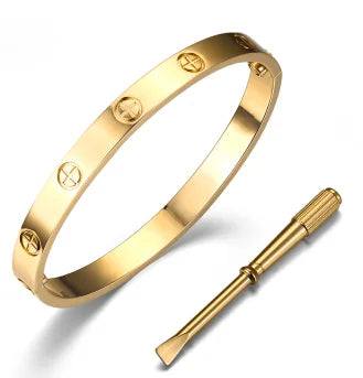 Polished gold-tone hinged cross bangle bracelet with screwdriver on white background