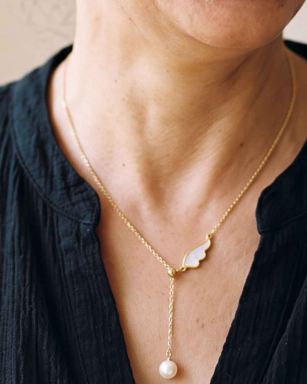 The gold Angelic Pearl worn by a woman, close-up, true to size