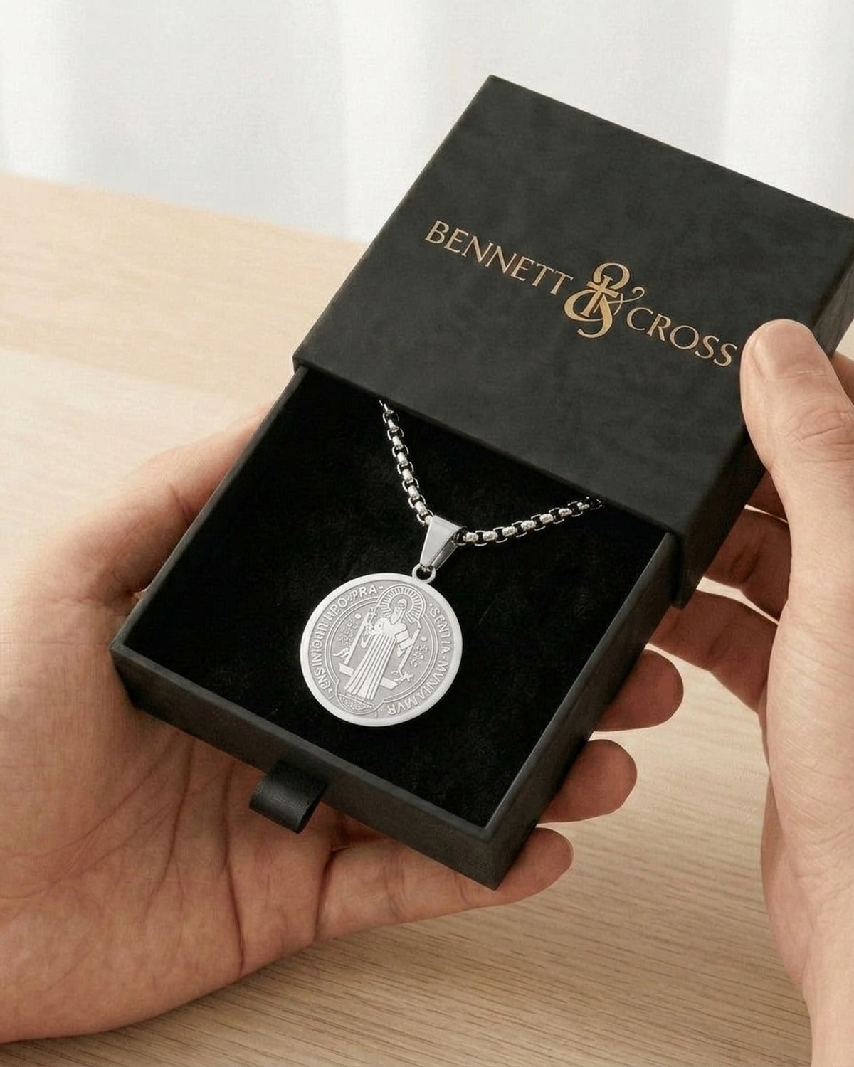 The silver Benedictine Medal in its black Bennett & Cross gift box
