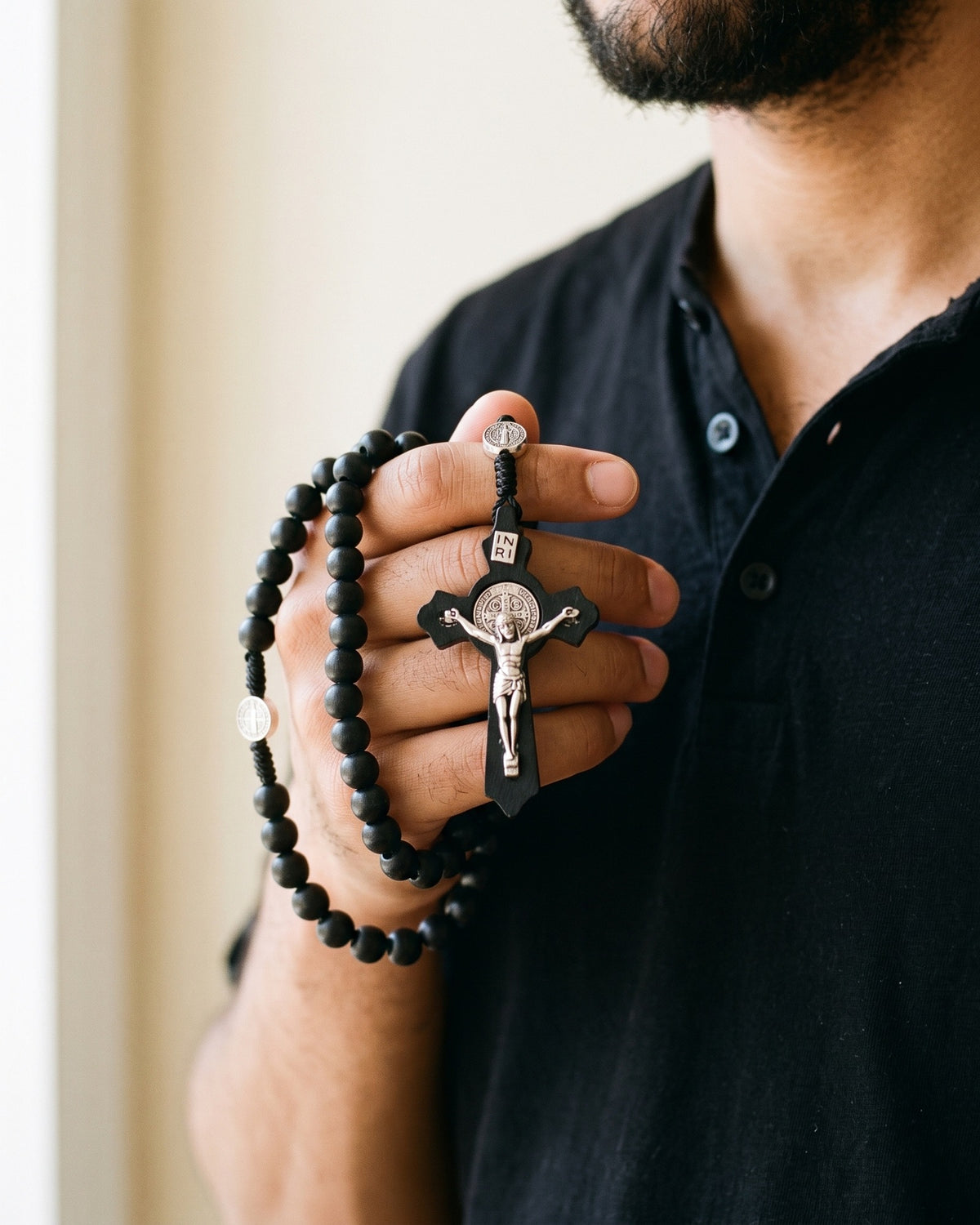Hands holding the crucifix of The Benedictine Path