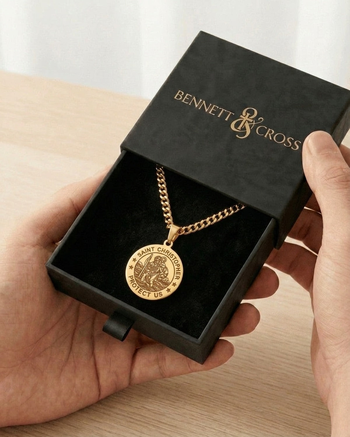 The Christopher Coin in its black Bennett & Cross gift box