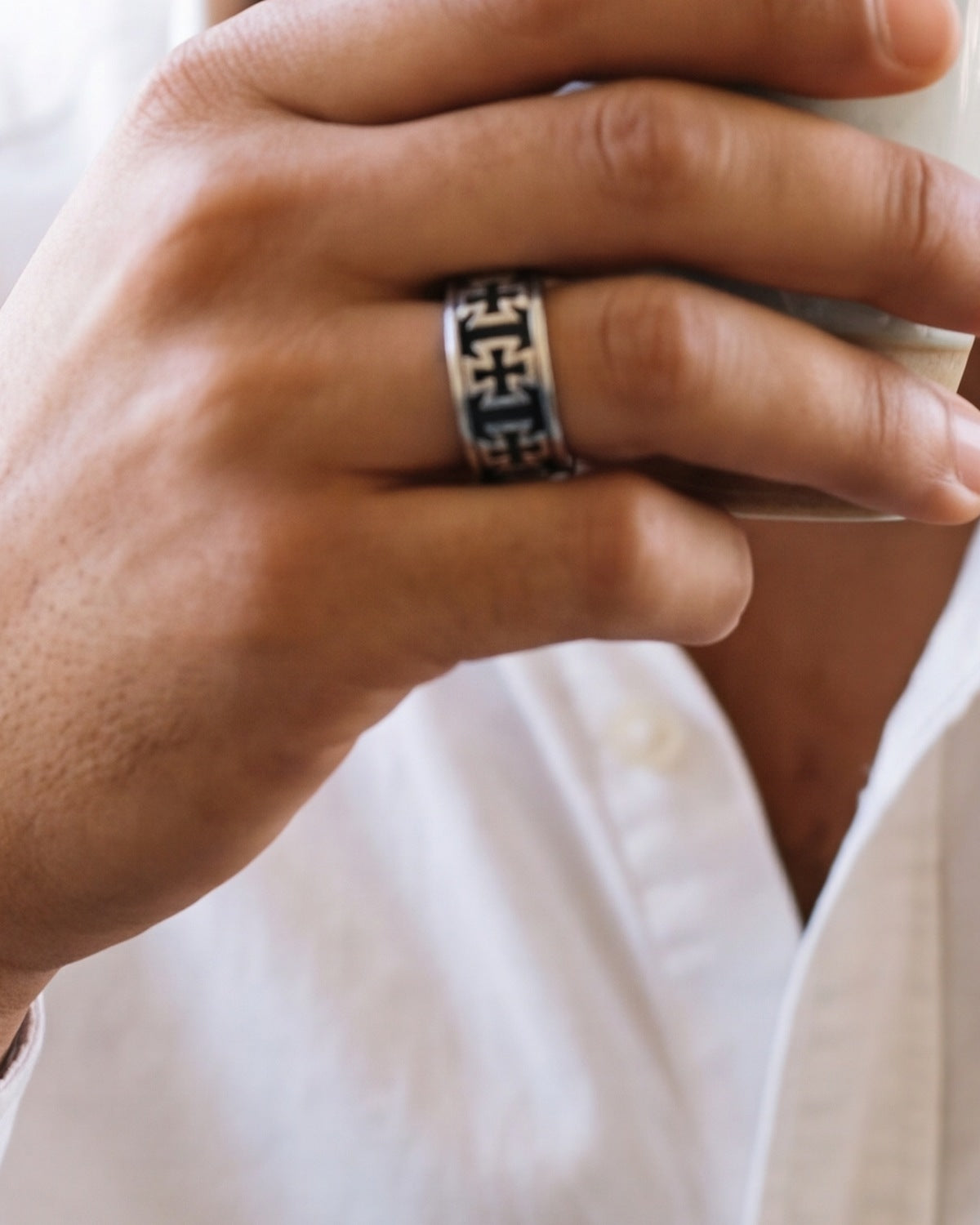 The Crusader Band on a man's finger, close-up, true to size