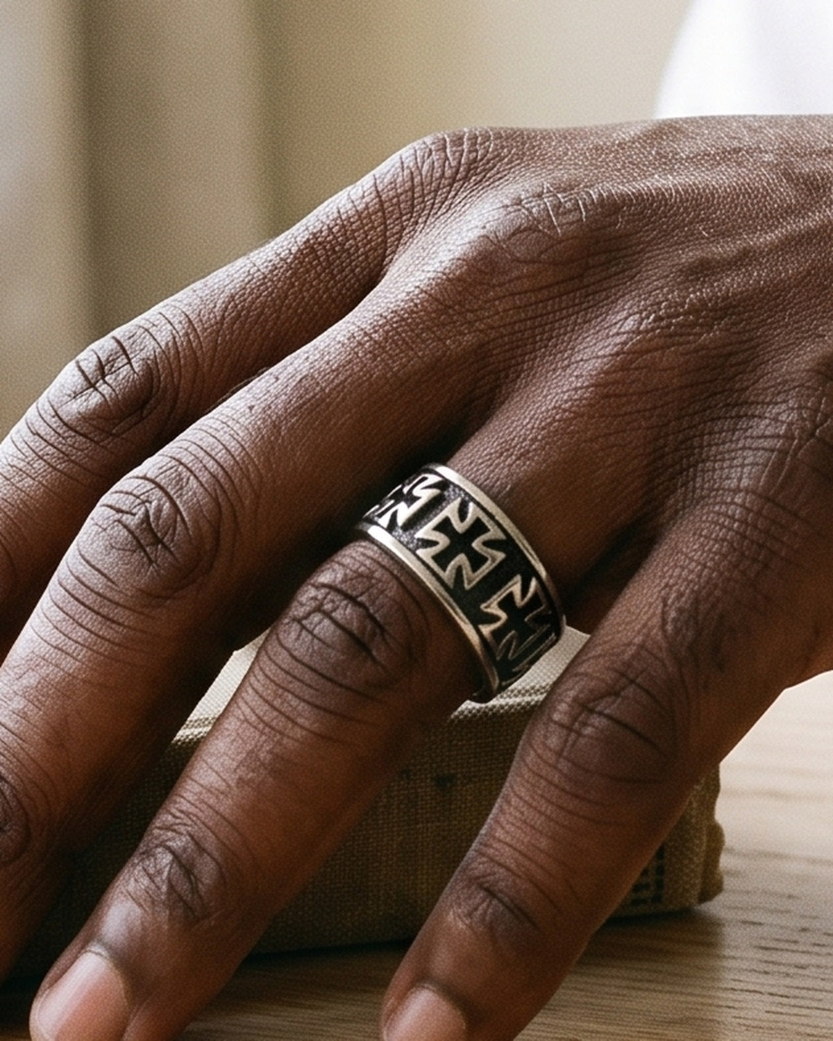 The Crusader Band on a man's finger, close-up, true to size