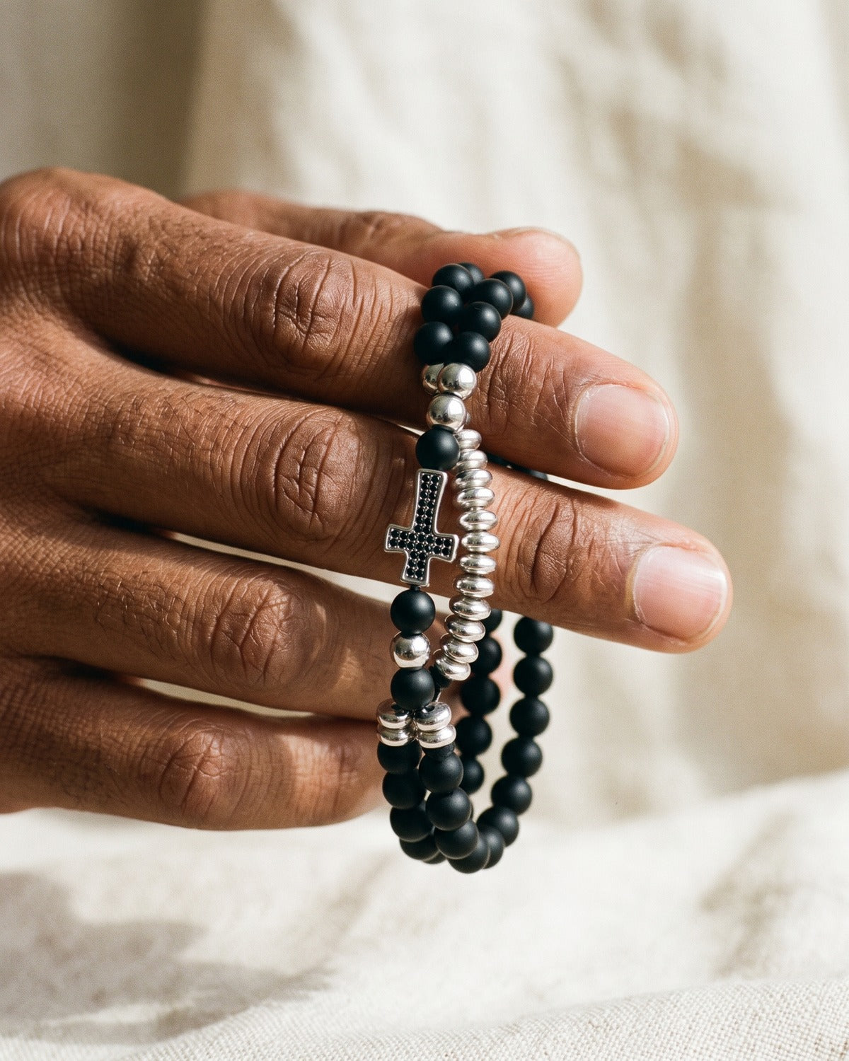 The Devout Strand bracelets held in the hand, true to size [c:silver]