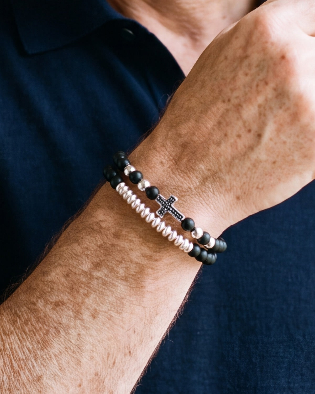 The Devout Strand bracelets worn on a man's wrist, close-up, true to size [c:silver]