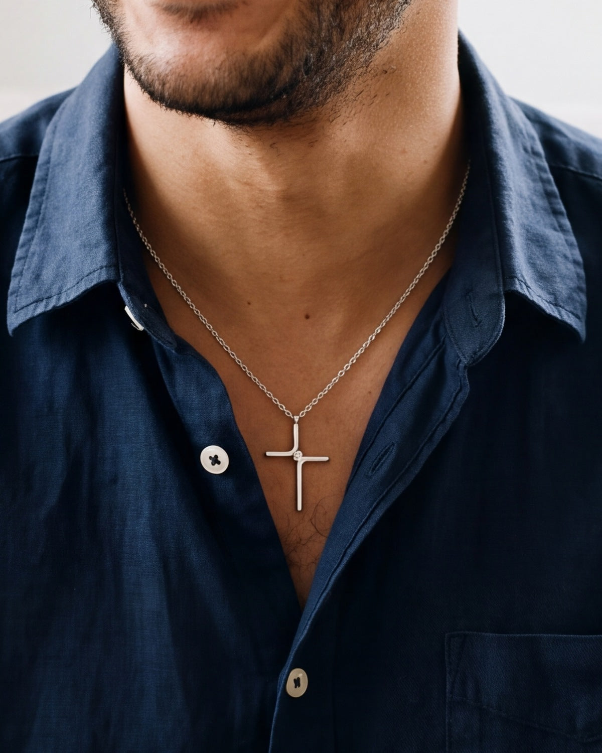 The silver Enduring Cross worn by a man, close-up, true to size [c:silver]