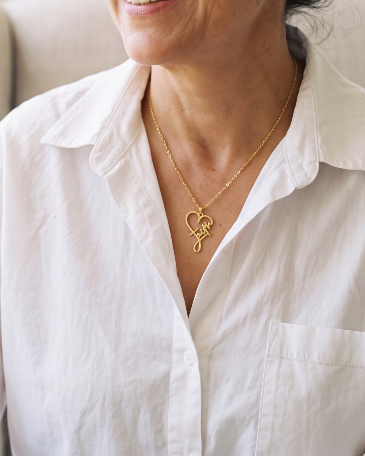 The gold Faithful Script worn by a woman, close-up from chin to chest, true to size [c:gold]