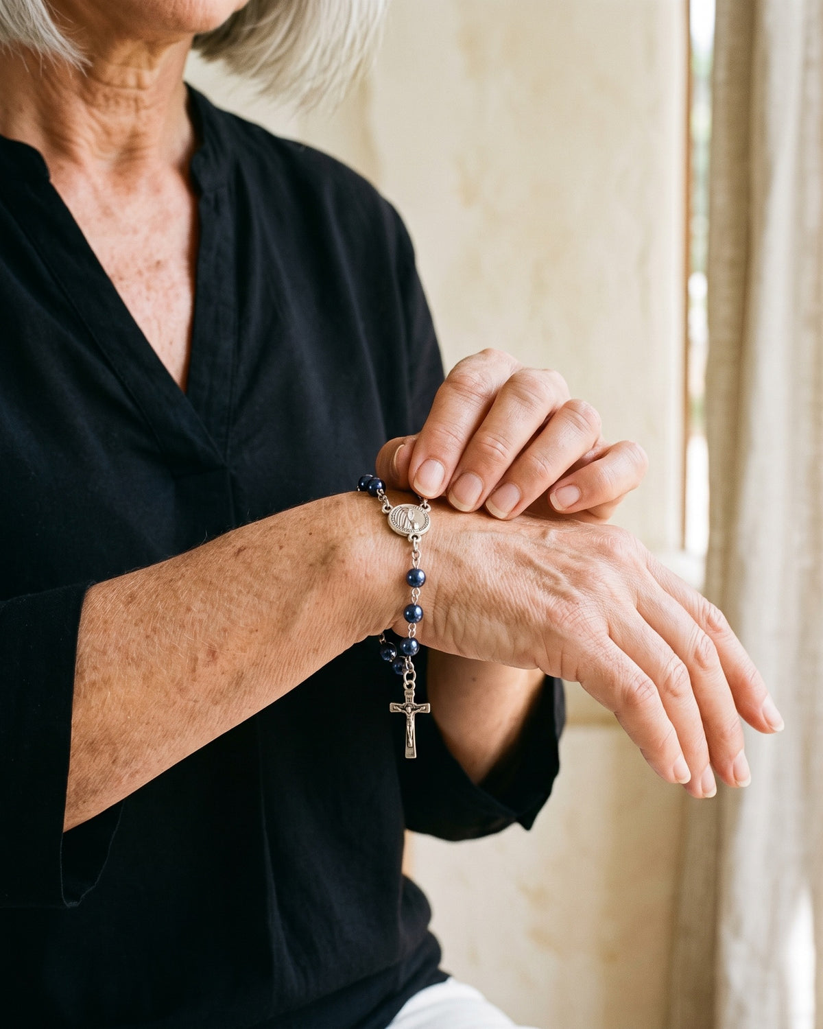 Woman adjusting The Fatima Decade on the wrist [c:navy-pearl]