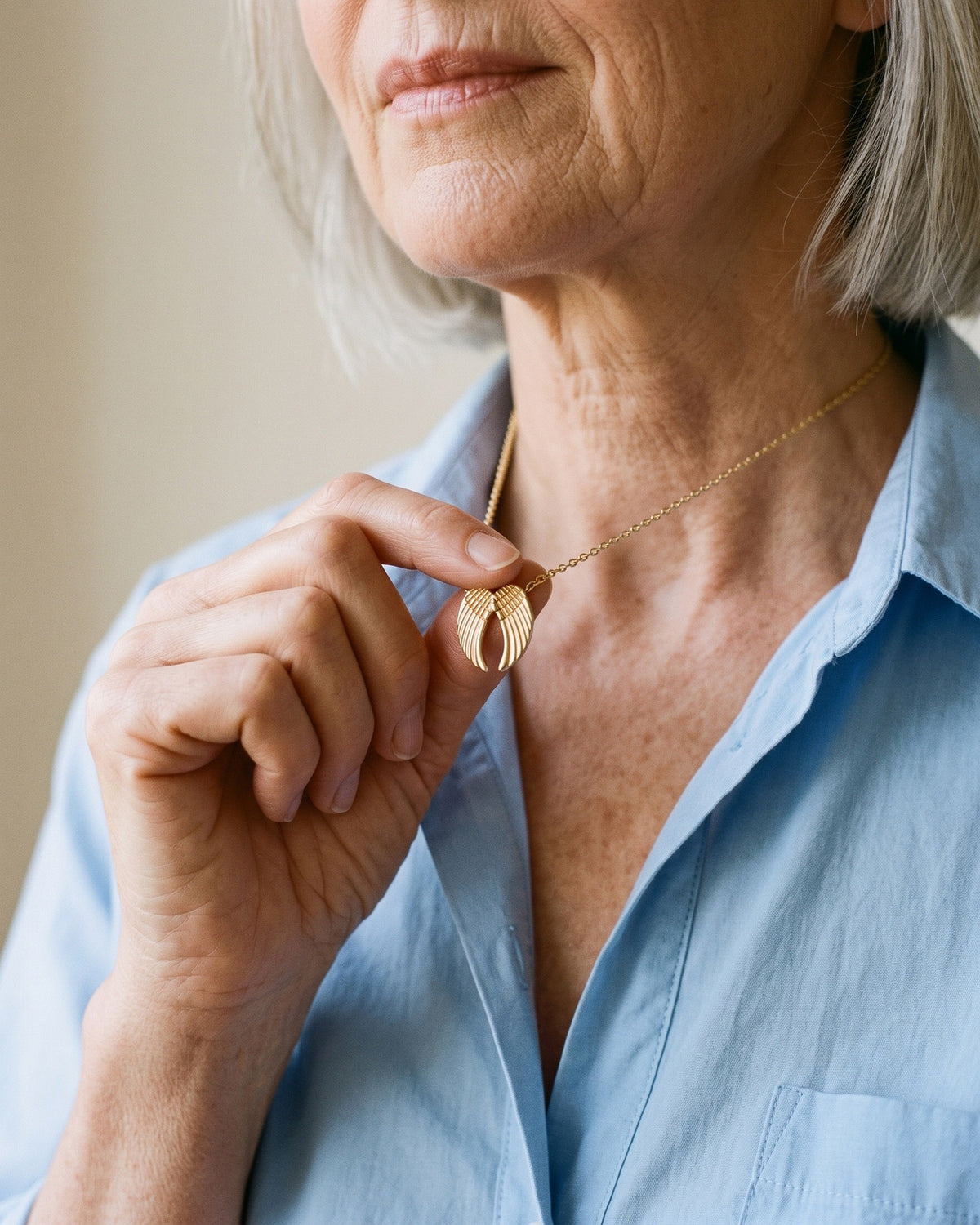 Woman holding The Folded Wings between the fingers [c:gold]