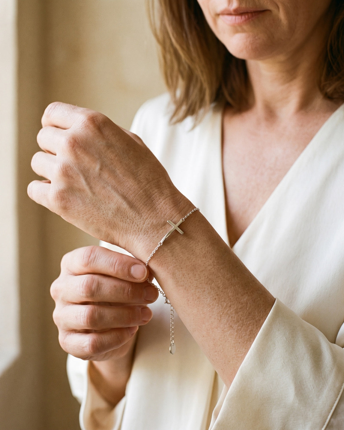 Woman adjusting The Graceful Cross bracelet on her wrist