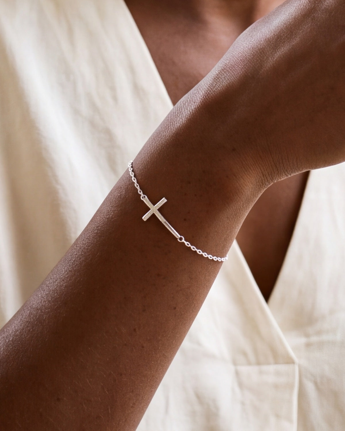 The Graceful Cross bracelet on the wrist, close-up, true to size