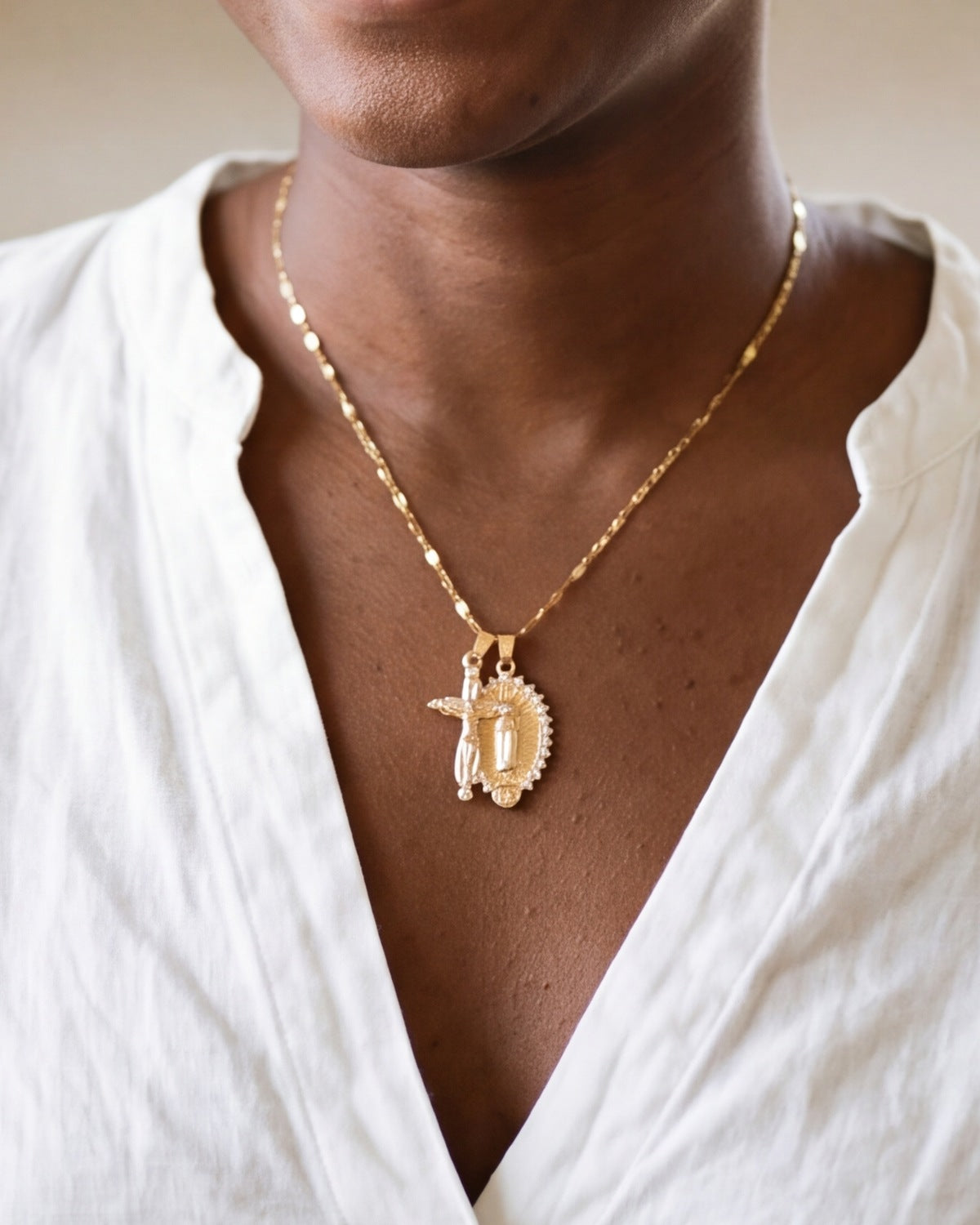 The gold Guadalupe Crucifix worn by a woman, close-up from chin to chest, true to size [c:gold]