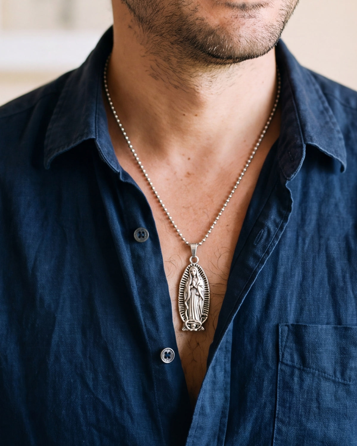The silver Guadalupe Relief worn by a man, close-up, true to size