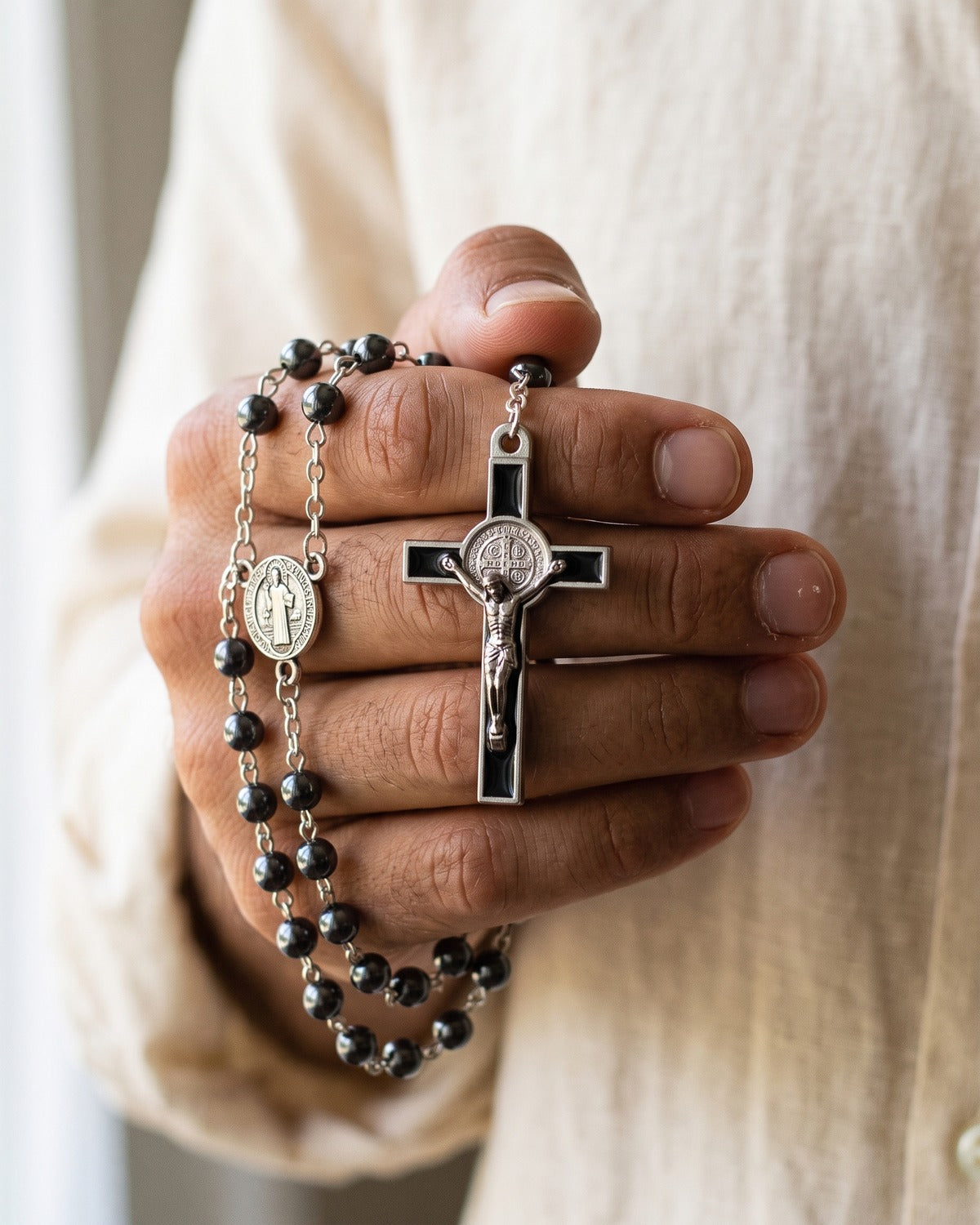 The Hematite Rosary crucifix in the hand, true to size