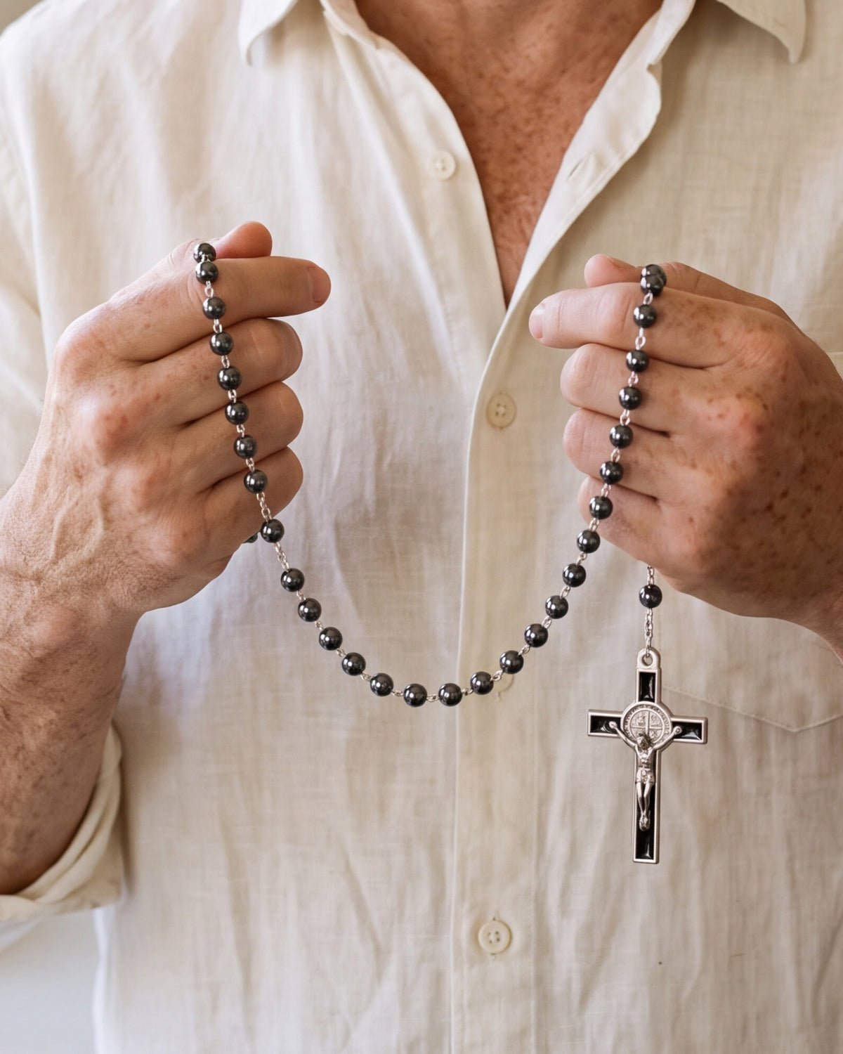 Hands holding The Hematite Rosary, close-up, true to size