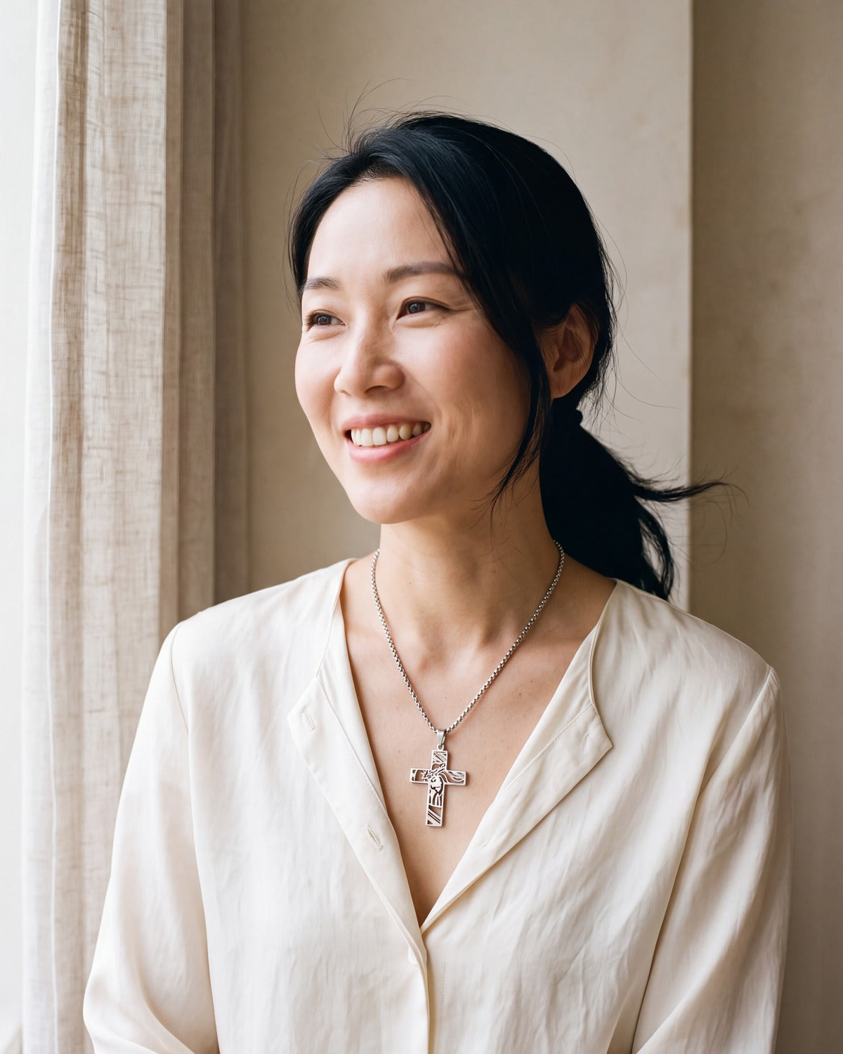 Smiling woman wearing The Holy Visage cross necklace [c:silver]