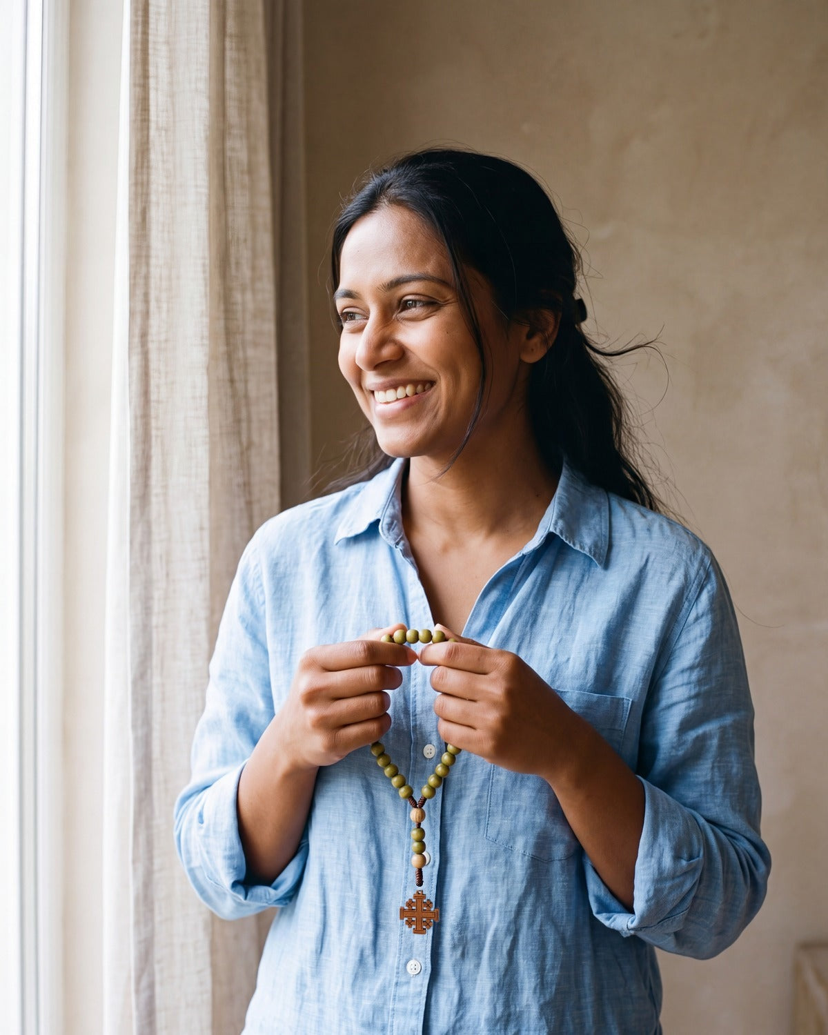 Smiling woman holding The Jerusalem Prayer rosary