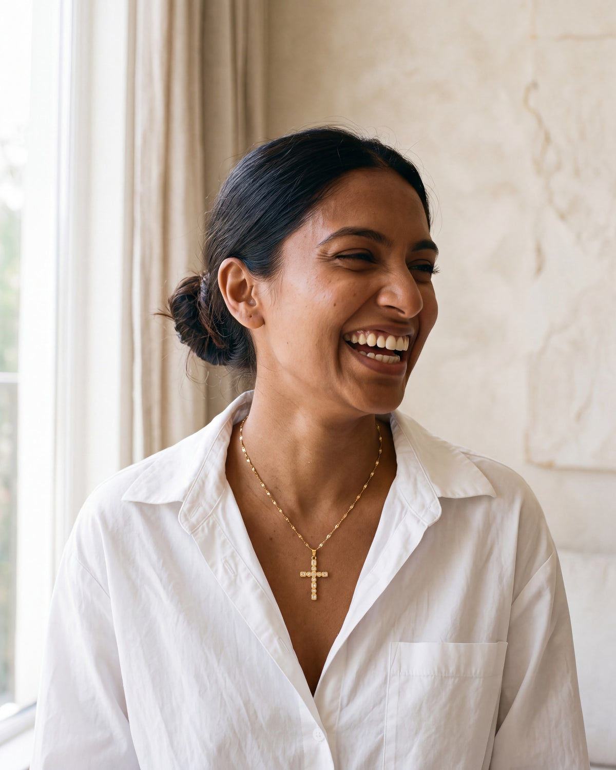 Smiling woman wearing the gold Jeweled Cross