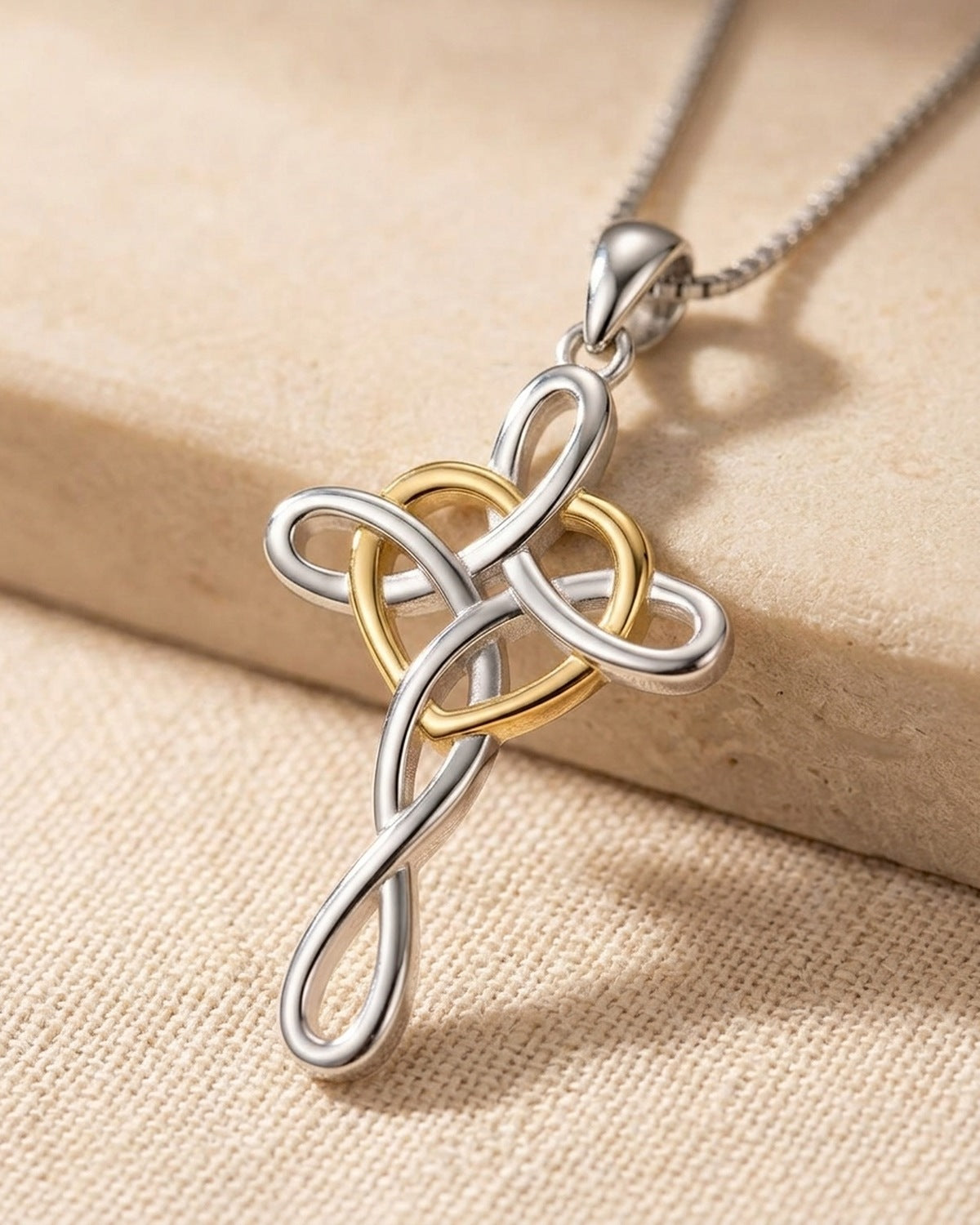 Close-up of The Knotted Heart Cross, silver with a gold heart