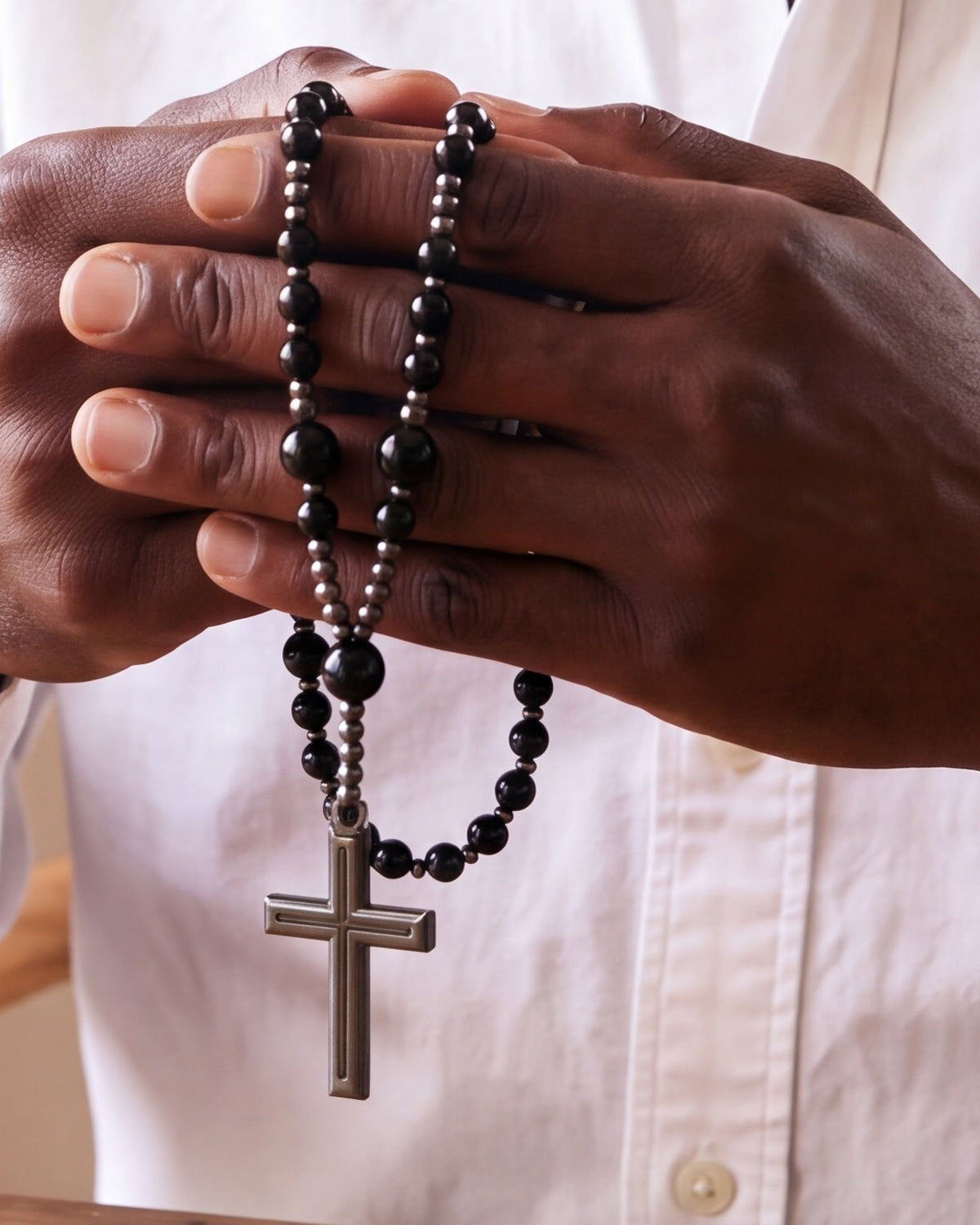The black Meditative Rosary held in a man's hands, close-up, true to size [c:black]