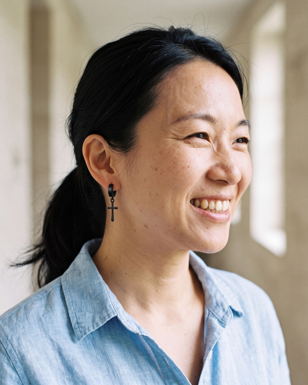 Smiling woman wearing the black Midnight Cross [c:black]