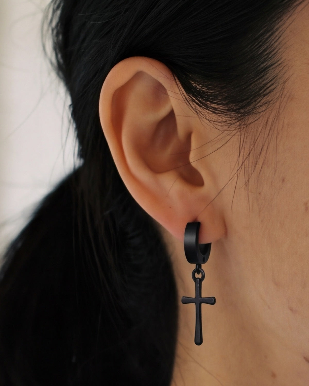 The black Midnight Cross worn by a woman, close-up, true to size [c:black]