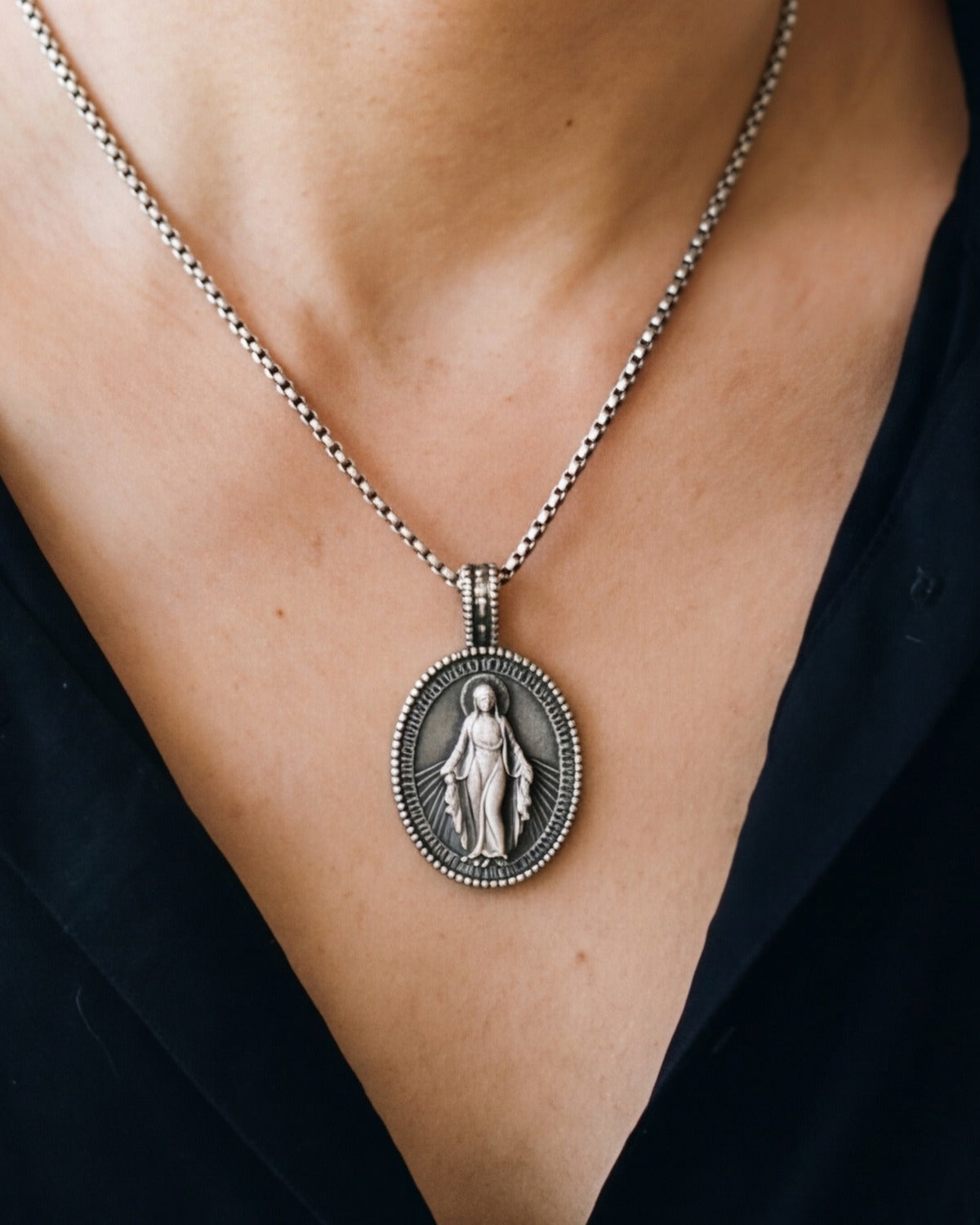 The antique silver Miraculous Emblem worn, close-up, true to size [c:antique-silver]