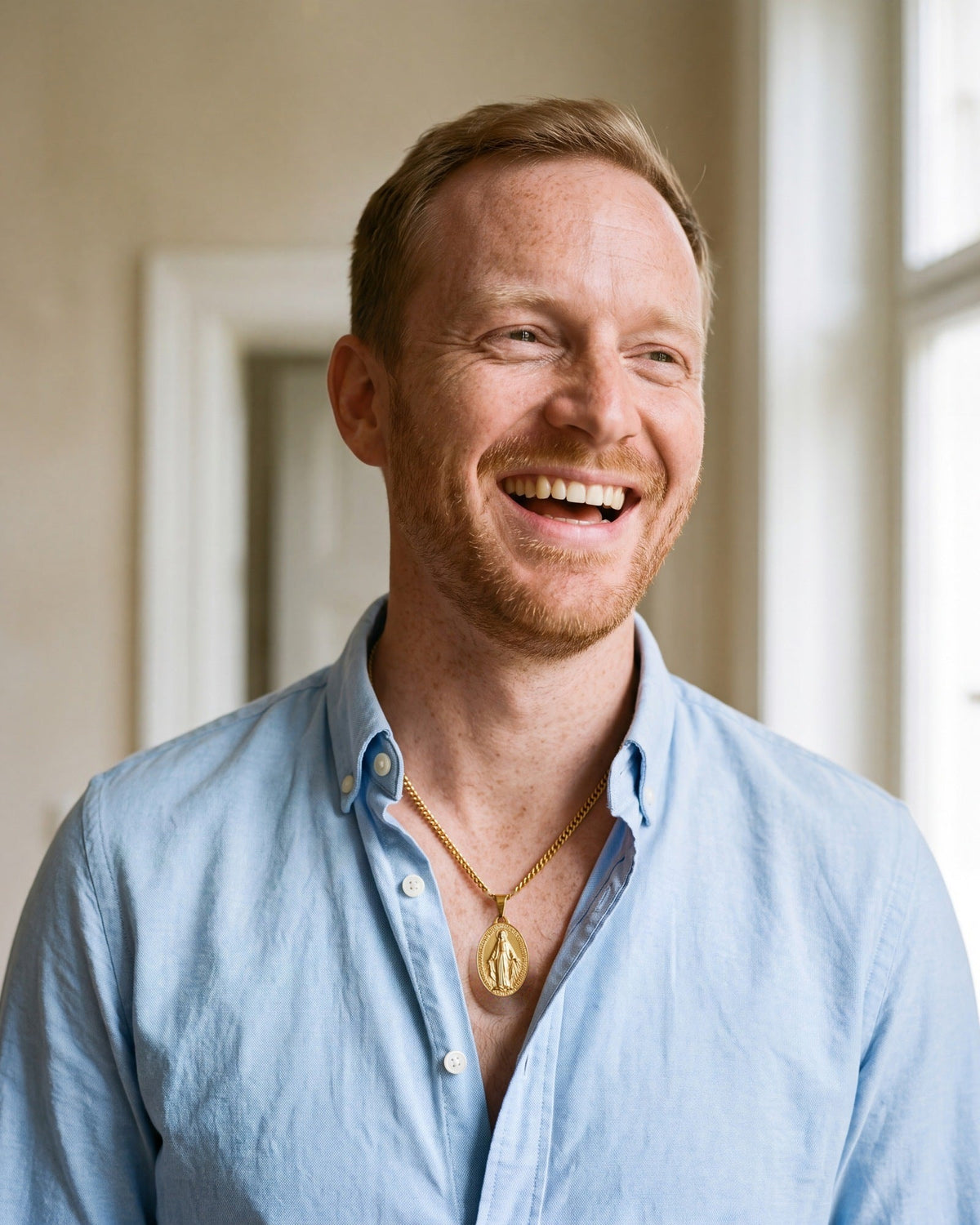 Smiling man wearing the gold Miraculous Medal