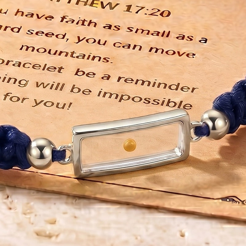 Close-up of the real mustard seed in its clear silver-tone frame, on the navy braided cord