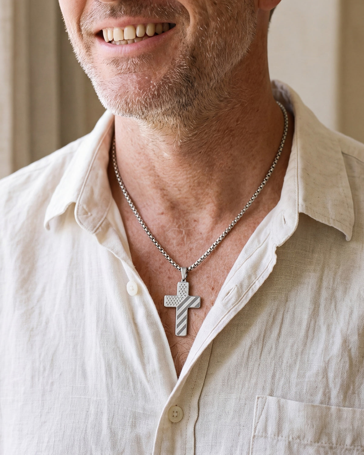 The Patriotic Scripture Cross worn by a smiling man, close-up on the flag cross pendant