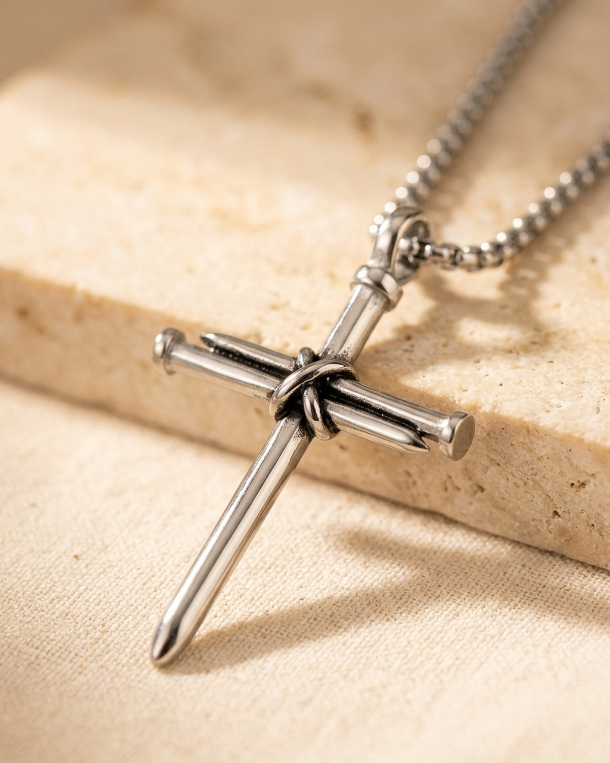 The Reverent Nails cross held in the hand, true to size [c:silver]