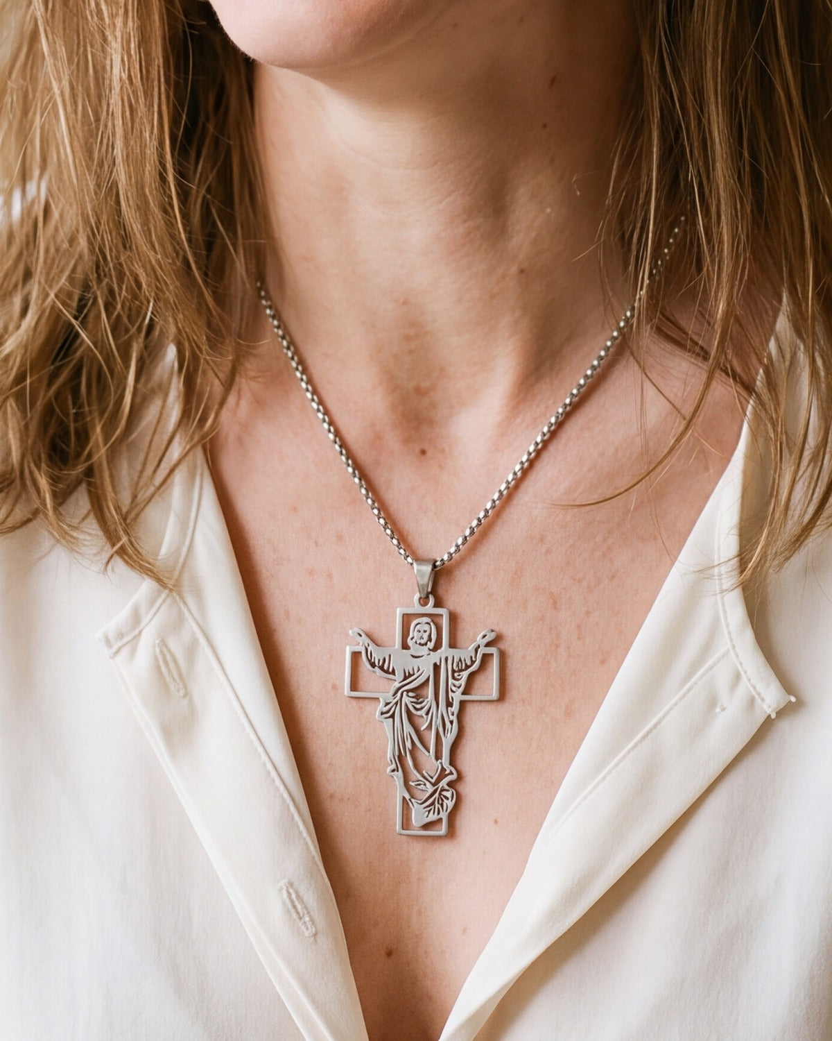 The silver Risen Christ worn by a woman, close-up from chin to chest, true to size [c:silver]