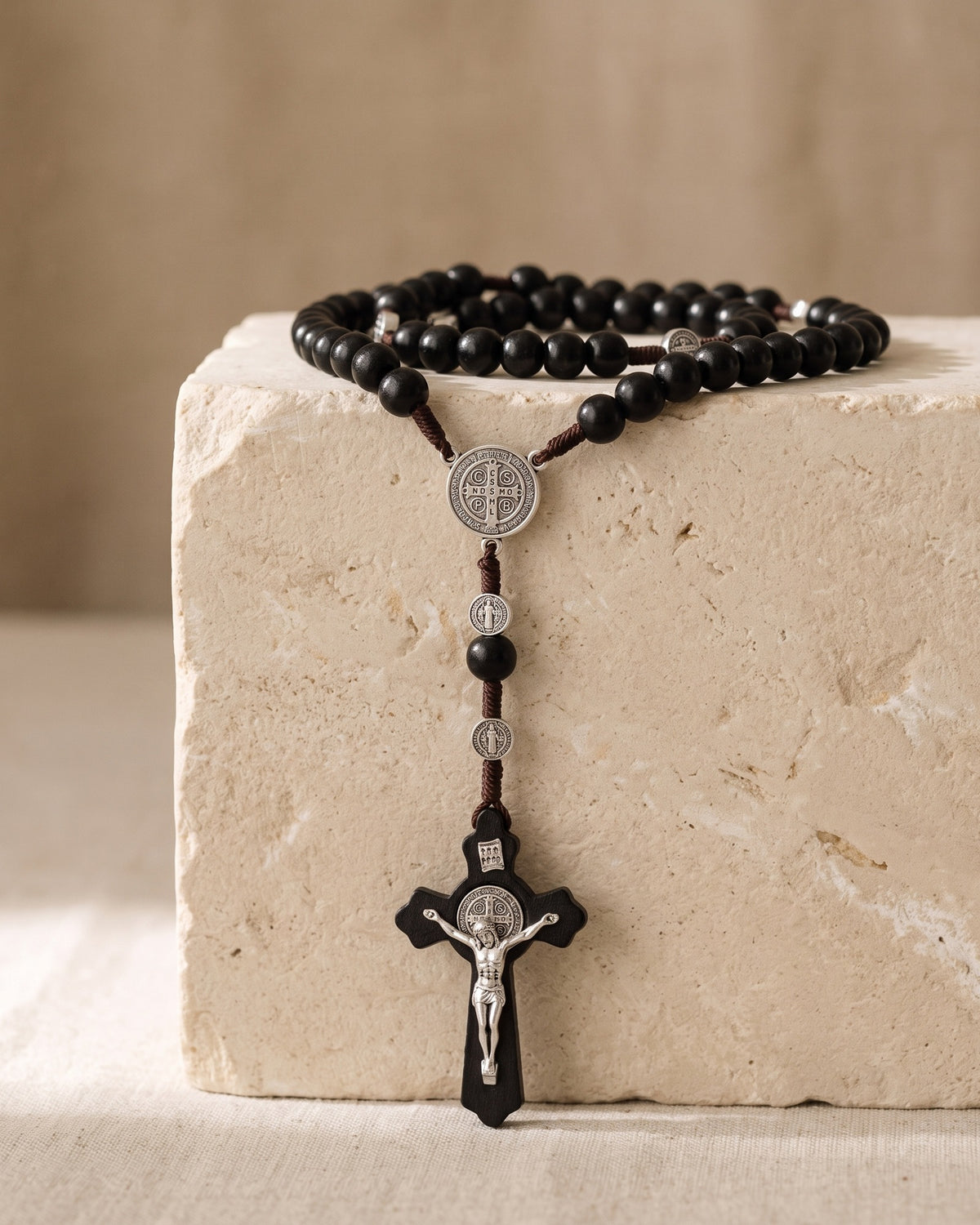The Rosary of Faith draped over a limestone block, Saint Benedict crucifix [c:black-beads]