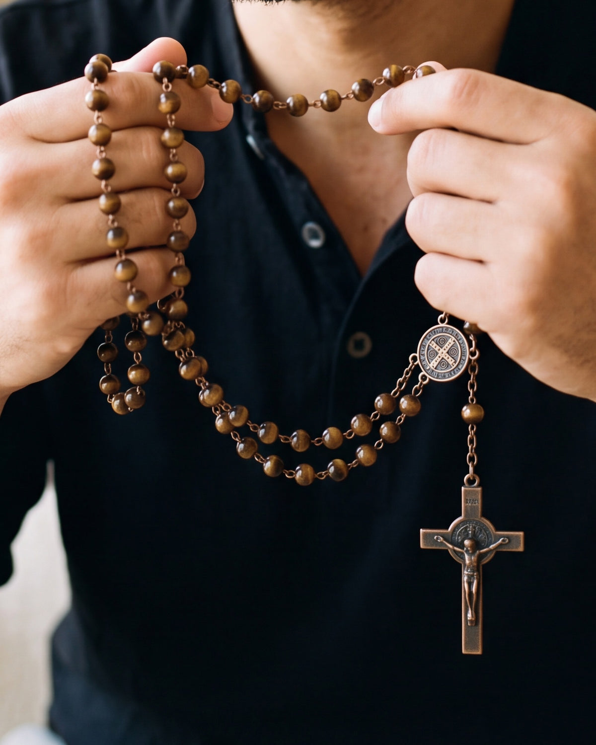 Hands holding The Saint Benedict Rosary, close-up, true to size