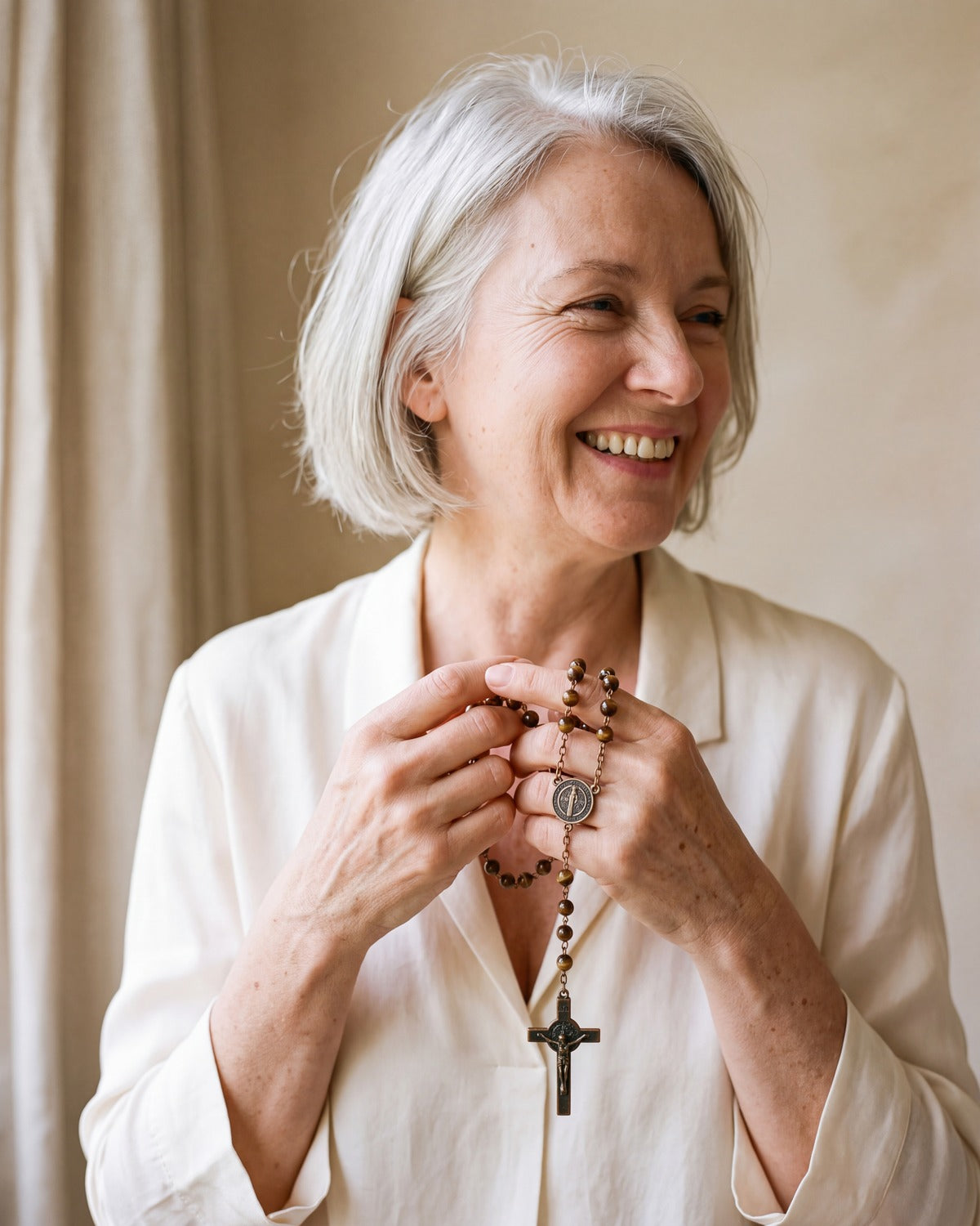 Smiling woman holding The Saint Benedict Rosary
