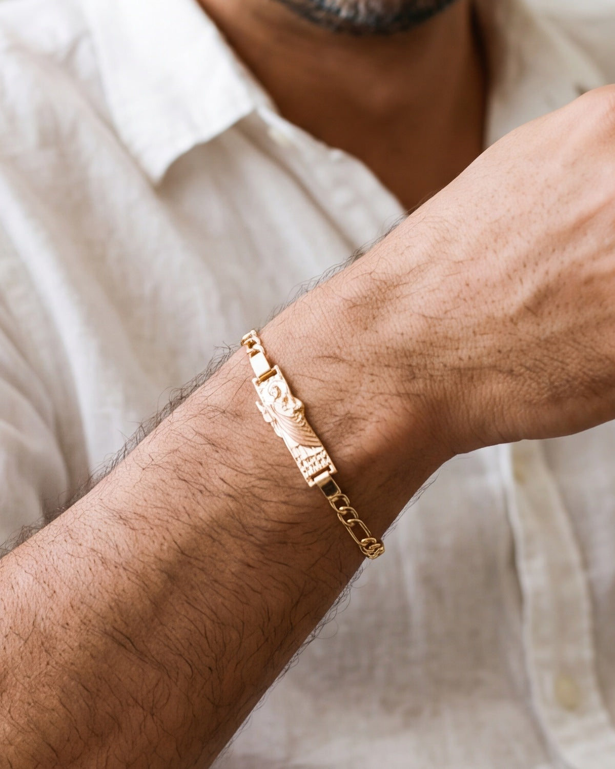 The Saint Jude Bracelet on a man's wrist, figaro chain, close-up, true to size [c:gold-robe]