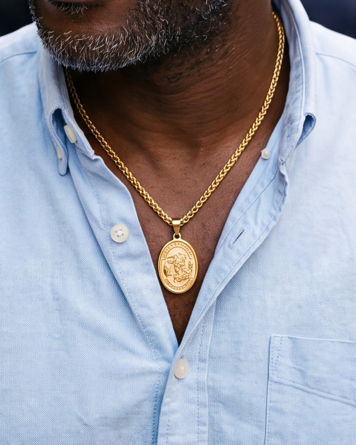 The gold Saint Michael Medal worn by a man, close-up from chin to chest, true to size [c:gold]