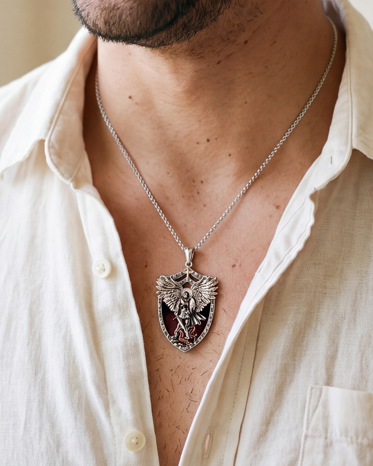 The Saint Michael Shield pendant worn by a man, close-up from chin to chest, true to size
