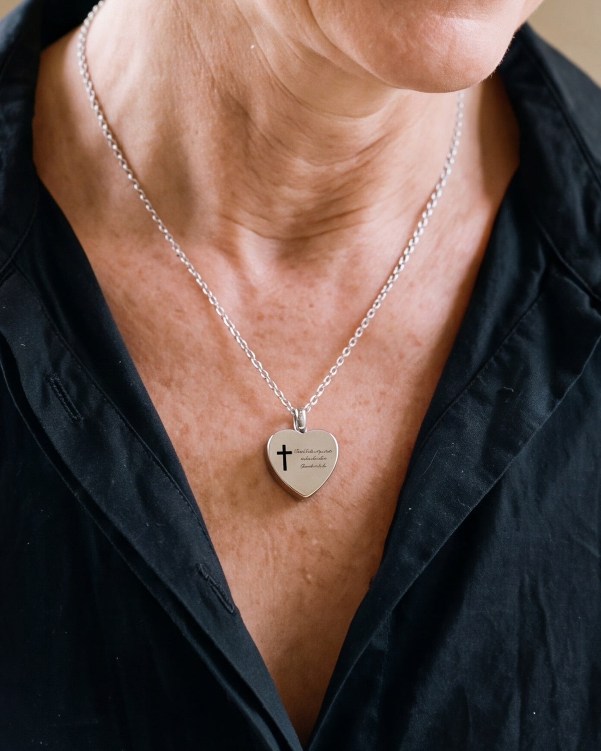 The Scripted Heart worn by a smiling woman, close-up on the heart pendant