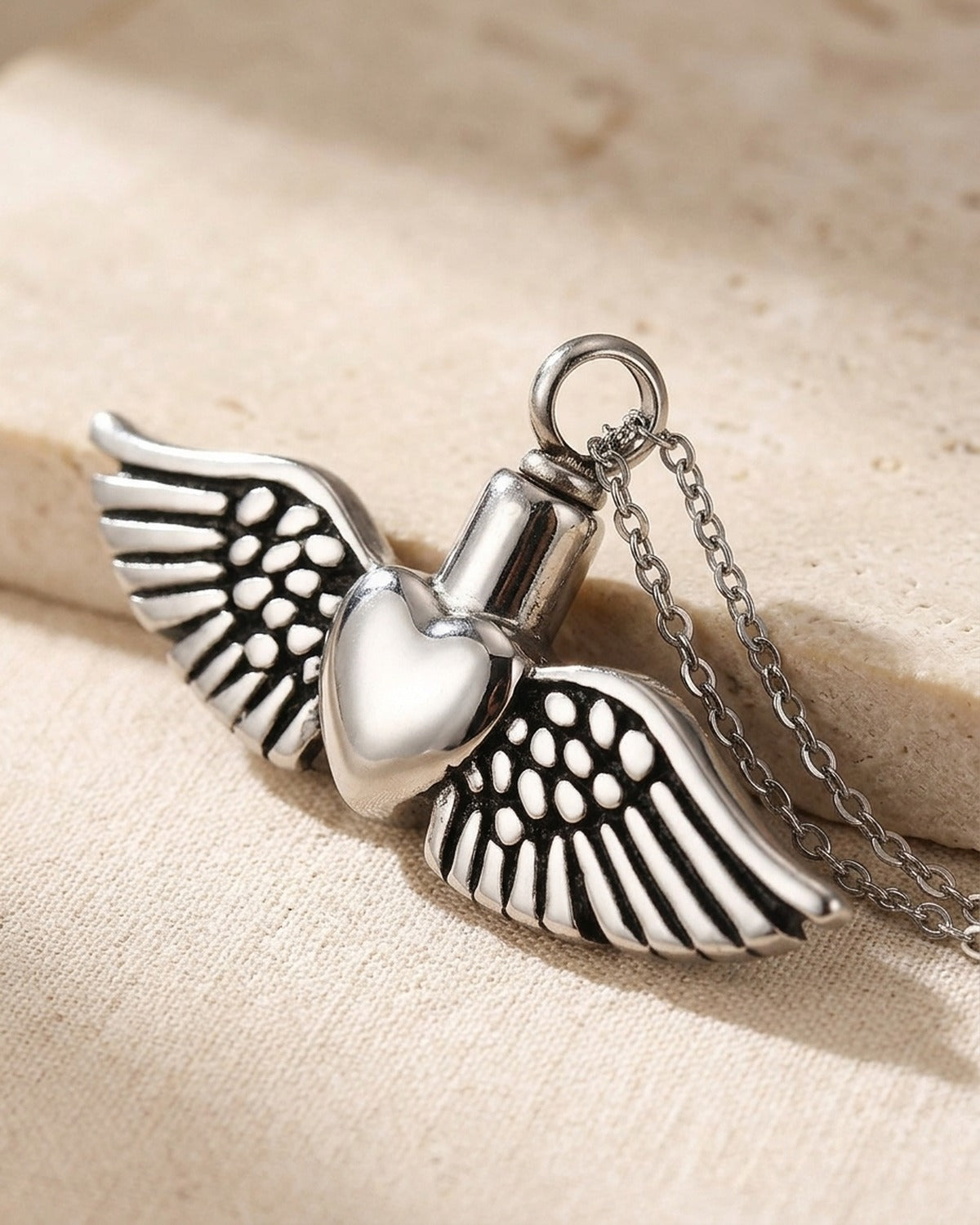 The Winged Heart pendant held in the hand, true to size